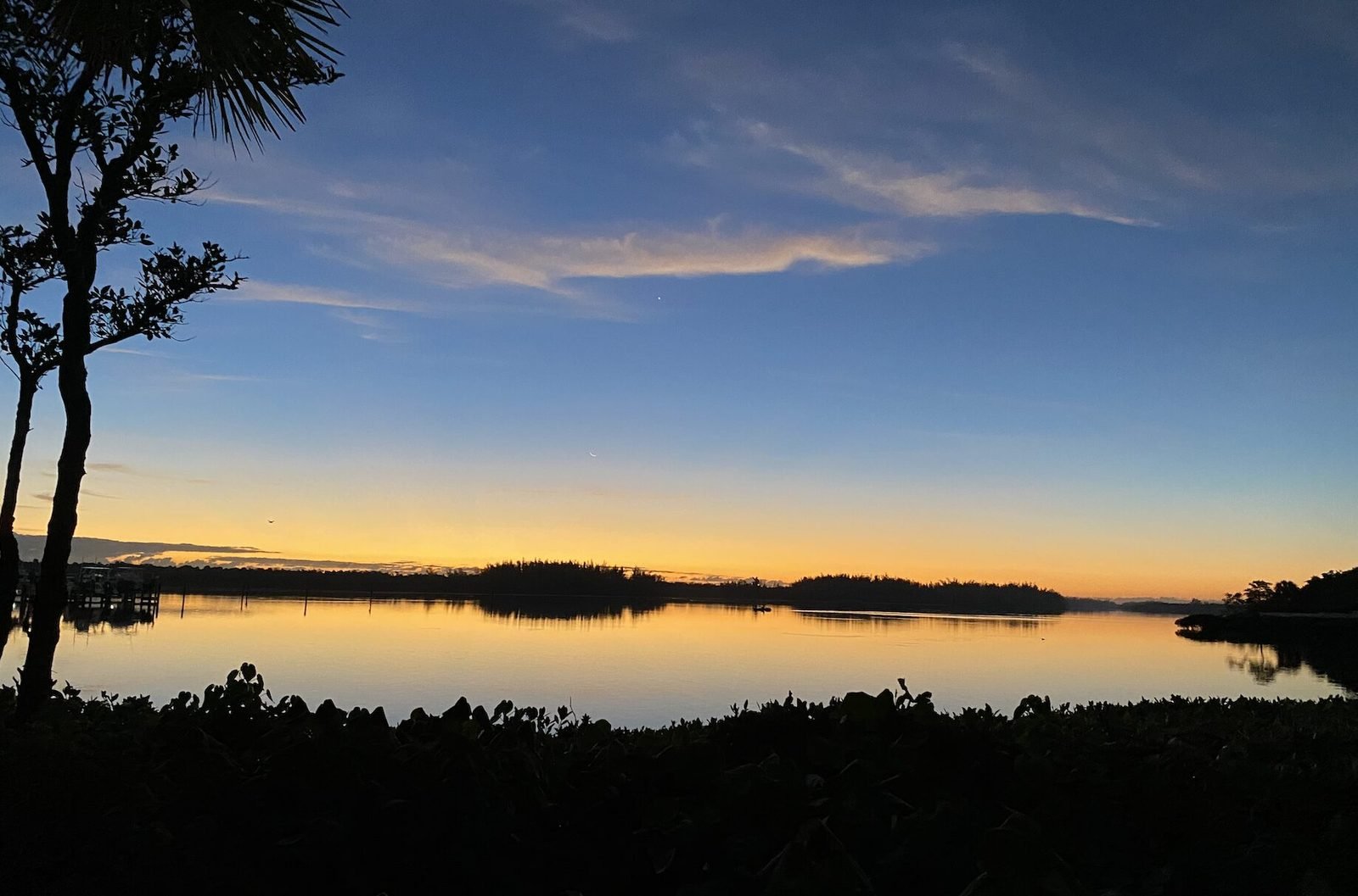Serene dawn over the Intracoastal, palms silhouetted against a golden horizon