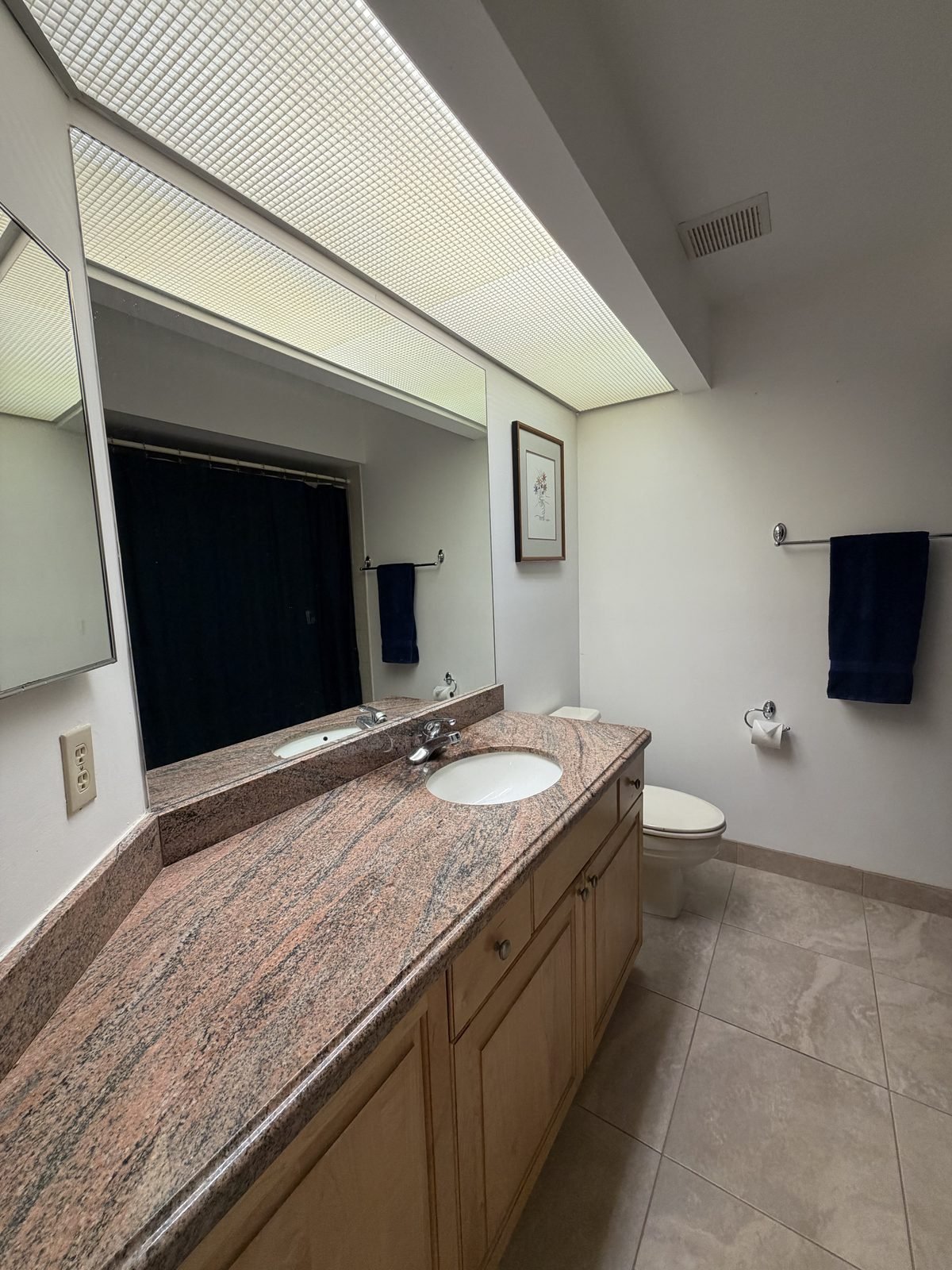 Guest bathroom with granite vanity, large mirror, and tile floor